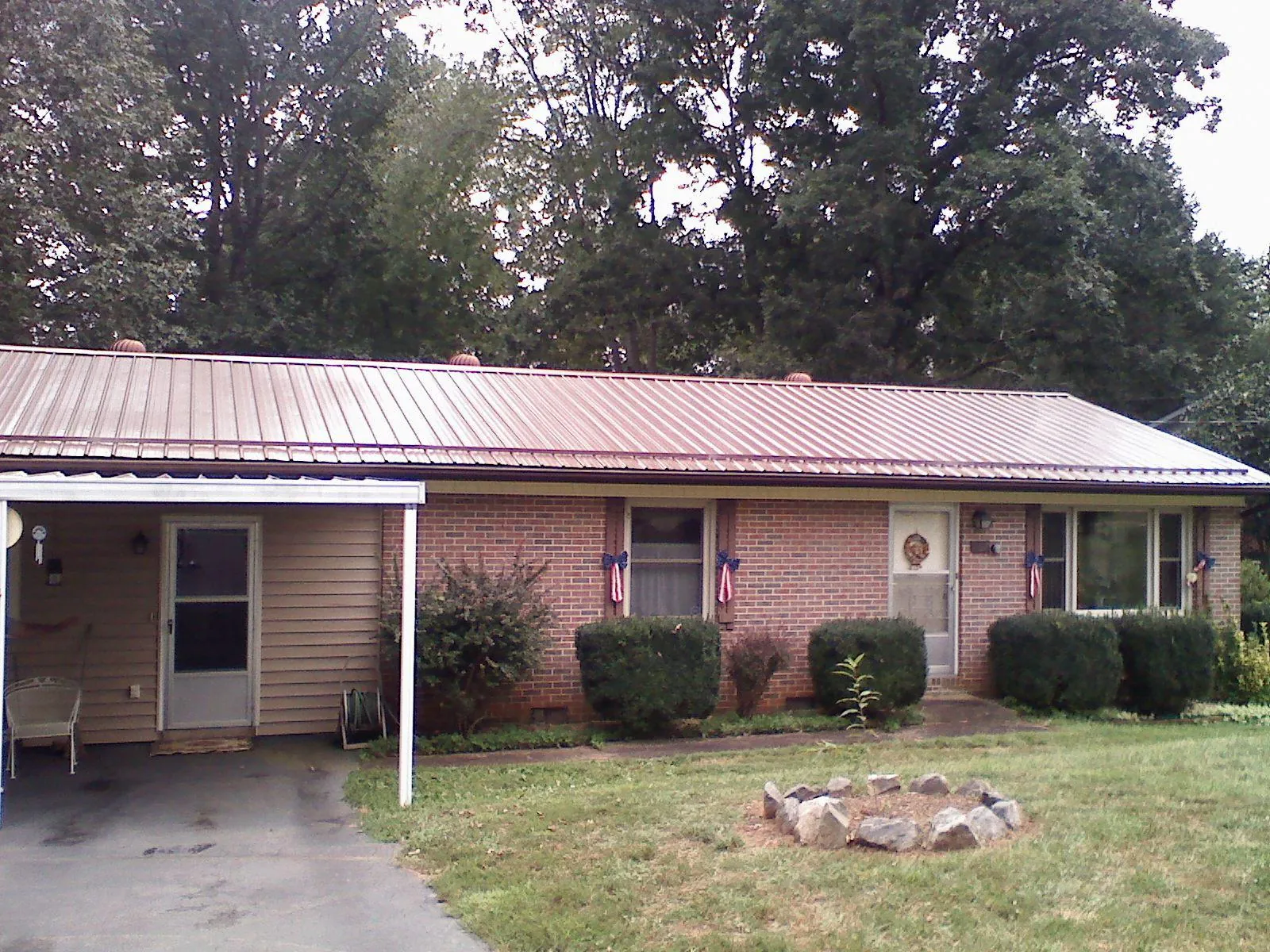 Bronze metal roof and carport on a brick ranch home — Roof Repair work by our crew in Pingree